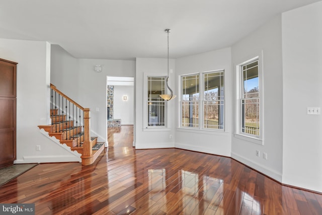 unfurnished dining area with dark hardwood / wood-style flooring and a chandelier