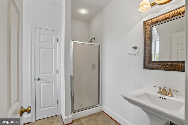 bathroom with walk in shower, tile floors, and sink