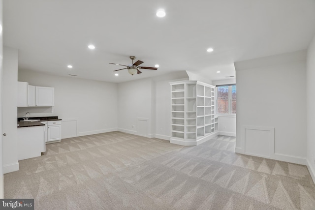 interior space featuring ceiling fan, sink, and light colored carpet