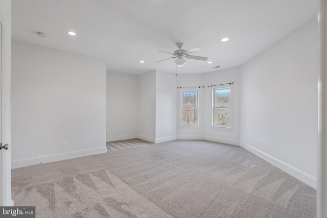 spare room featuring light carpet and ceiling fan