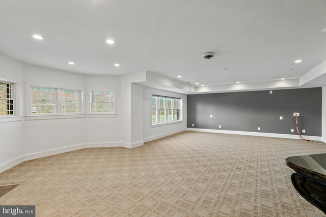 carpeted empty room with a tray ceiling