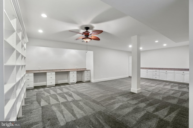 basement with dark colored carpet and ceiling fan