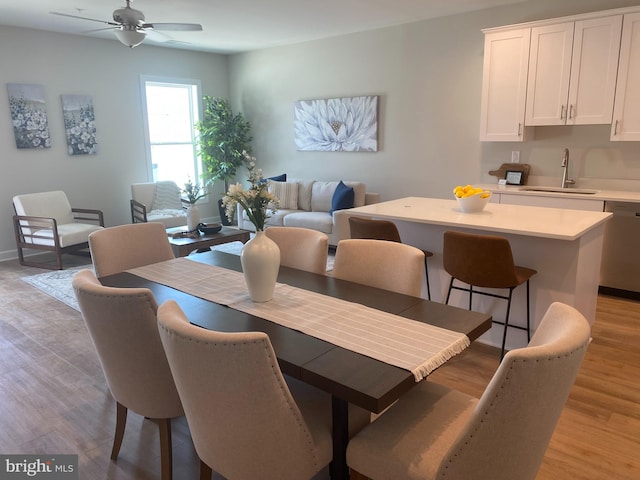 dining area featuring ceiling fan, sink, and light hardwood / wood-style flooring