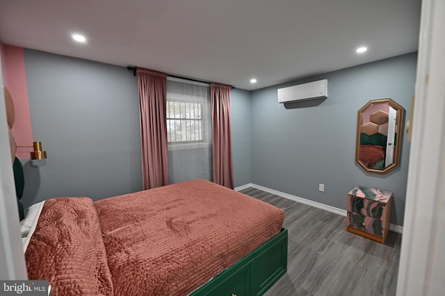 bedroom featuring a wall mounted AC and hardwood / wood-style floors