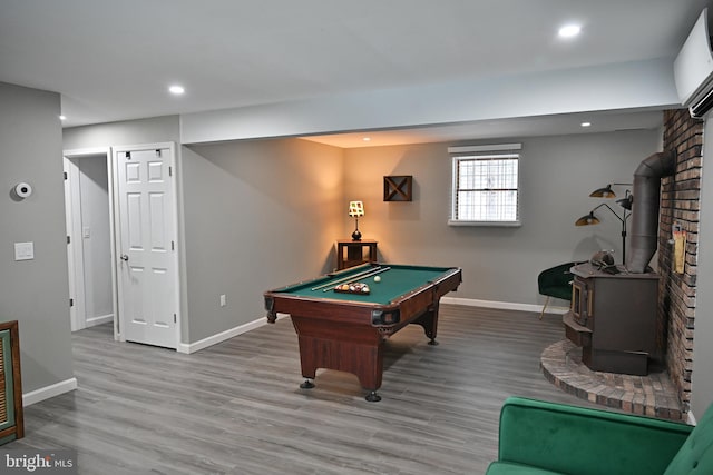 rec room featuring hardwood / wood-style flooring, billiards, and a wood stove