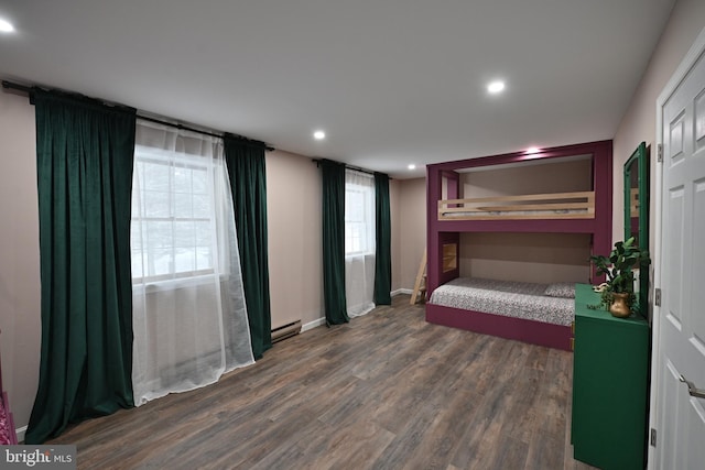 bedroom featuring baseboard heating and dark hardwood / wood-style floors