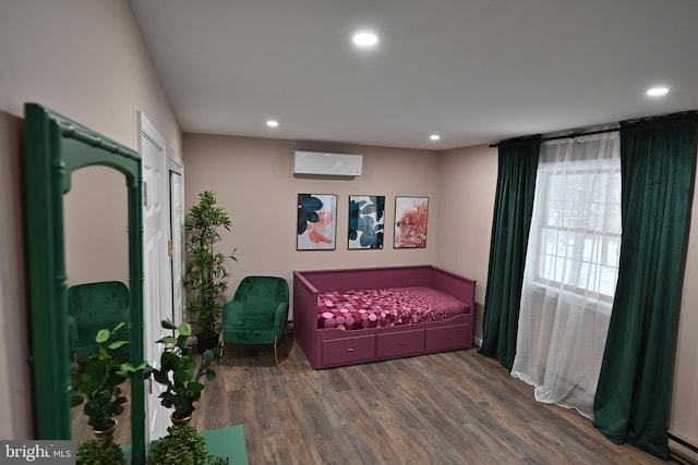 bedroom with dark wood-type flooring, a baseboard radiator, and a wall unit AC