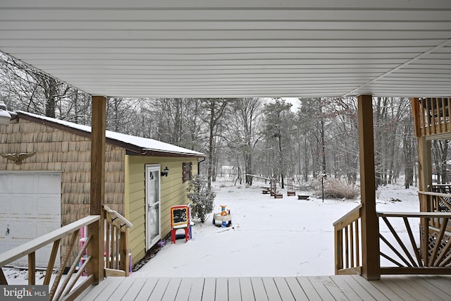 snow covered deck featuring a garage