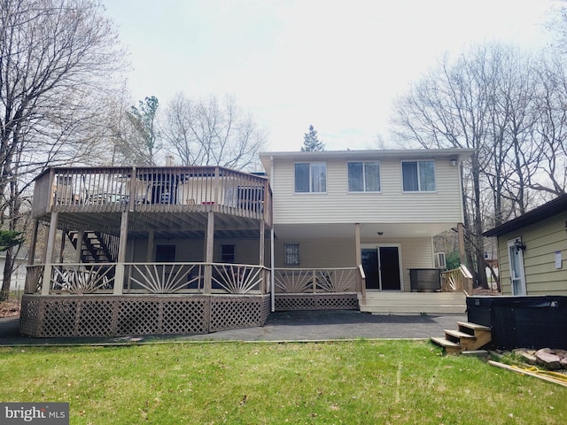 back of house featuring a deck and a lawn