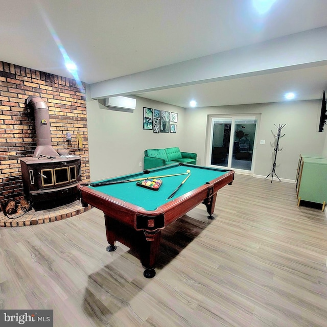 recreation room with light wood-type flooring, pool table, and a wood stove