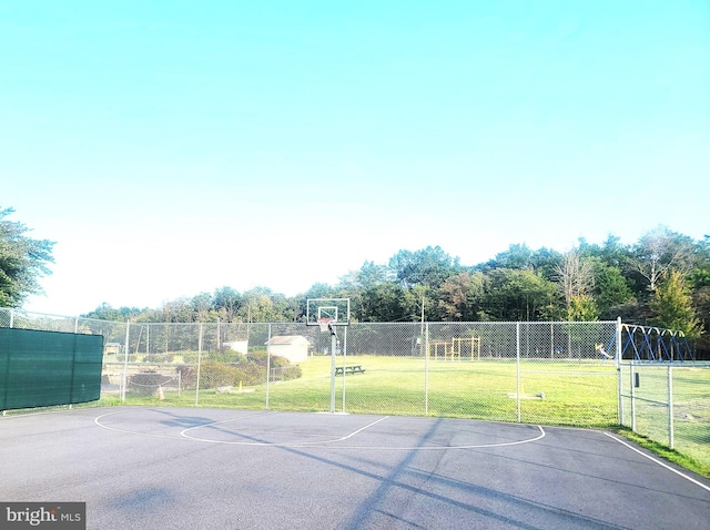 view of sport court with a lawn