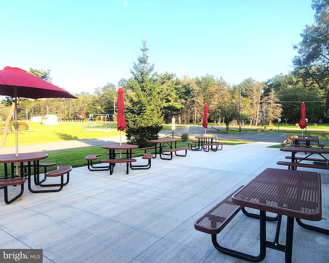 view of property's community featuring a lawn and a patio