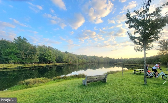 exterior space with a water view and a lawn