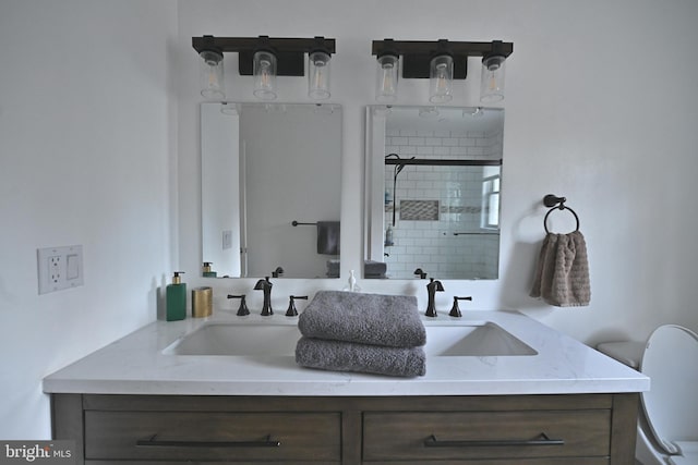 bathroom with vanity, toilet, and a tile shower