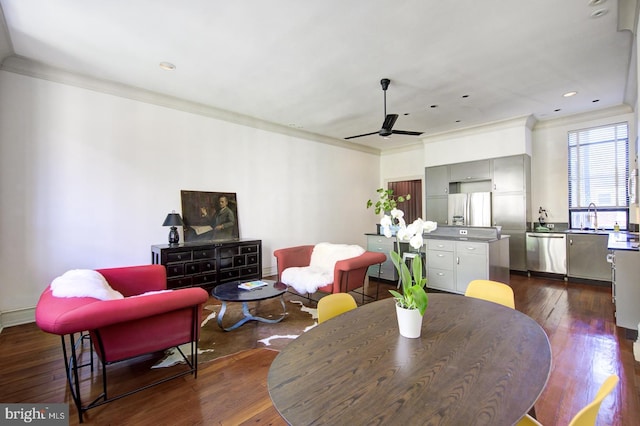 dining area with crown molding, ceiling fan, dark wood-type flooring, and sink