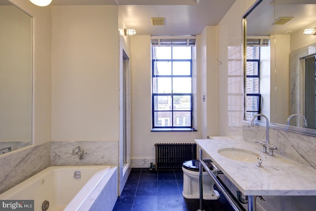 bathroom featuring toilet, large vanity, radiator heating unit, and plenty of natural light