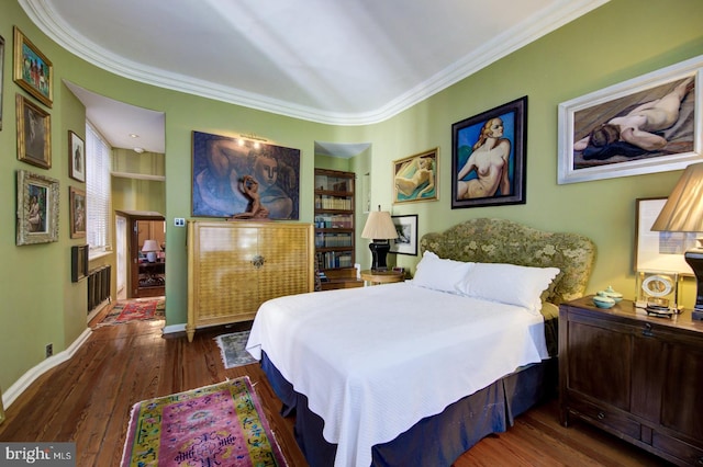 bedroom with ornamental molding and dark wood-type flooring