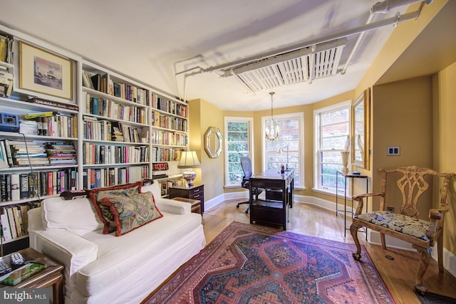 sitting room featuring an inviting chandelier and hardwood / wood-style floors