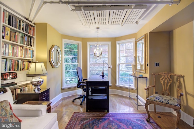 office area featuring plenty of natural light, a notable chandelier, and hardwood / wood-style flooring