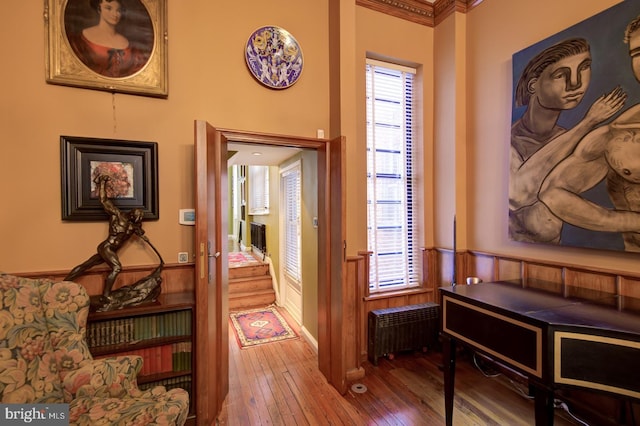 hallway featuring plenty of natural light, radiator heating unit, ornamental molding, and dark wood-type flooring