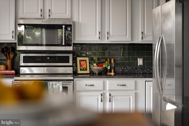 kitchen with appliances with stainless steel finishes, white cabinets, and backsplash