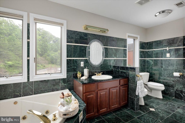 bathroom featuring tile flooring, vanity with extensive cabinet space, toilet, and tile walls