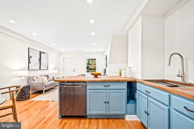 kitchen with light hardwood / wood-style floors, butcher block counters, blue cabinetry, stainless steel dishwasher, and sink