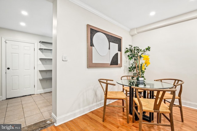 dining area with light hardwood / wood-style flooring and ornamental molding