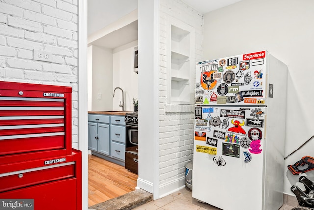 kitchen featuring light hardwood / wood-style floors, black range, and sink