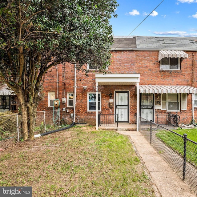 townhome / multi-family property featuring a front yard