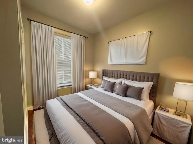 bedroom with multiple windows and hardwood / wood-style flooring