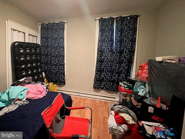 bedroom featuring hardwood / wood-style floors and a baseboard radiator