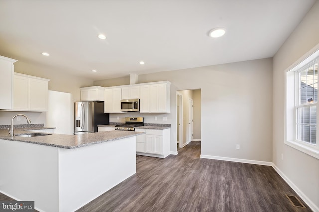 kitchen with stainless steel appliances, dark hardwood / wood-style flooring, white cabinetry, and sink