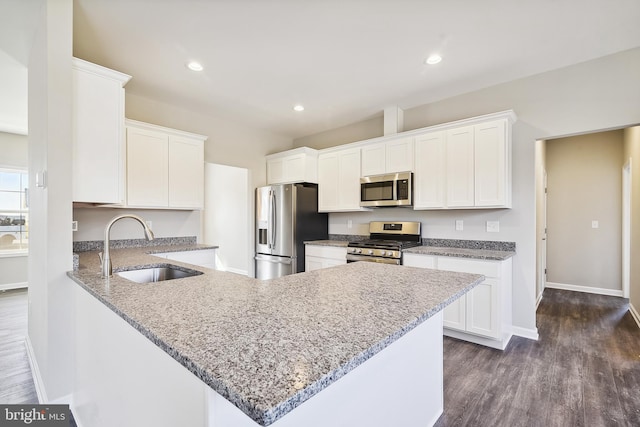 kitchen featuring sink, white cabinetry, light stone countertops, dark hardwood / wood-style floors, and appliances with stainless steel finishes