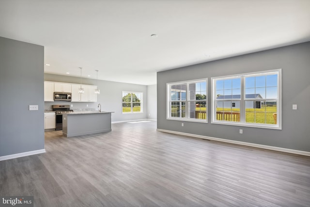 unfurnished living room featuring sink and light wood-type flooring