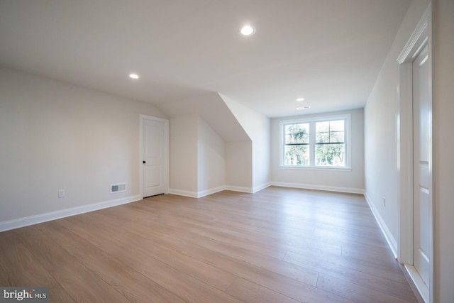 additional living space with light hardwood / wood-style floors