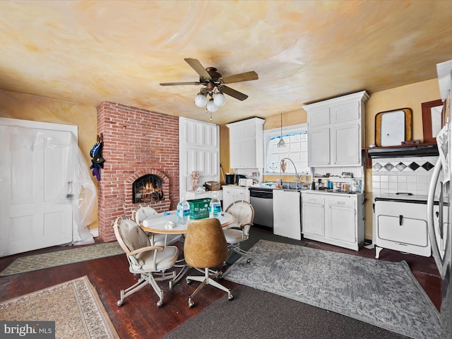 dining area featuring ceiling fan, brick wall, a brick fireplace, and dark hardwood / wood-style flooring