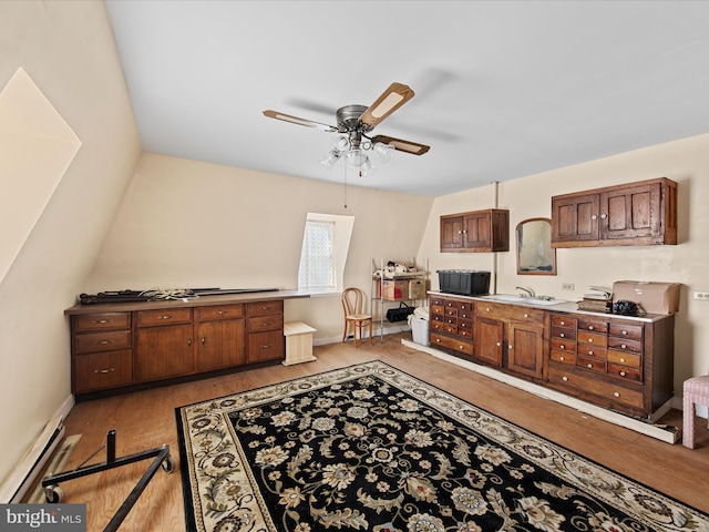 interior space with light hardwood / wood-style floors, ceiling fan, lofted ceiling, and baseboard heating