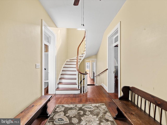 foyer entrance with ceiling fan and dark wood-type flooring