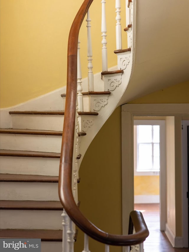 stairway featuring wood-type flooring and vaulted ceiling