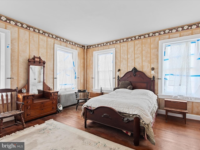 bedroom featuring dark hardwood / wood-style flooring and radiator heating unit