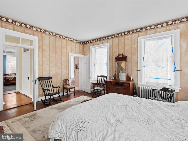 bedroom featuring radiator heating unit and dark wood-type flooring