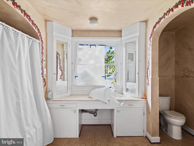 bathroom with toilet, tile floors, and vanity