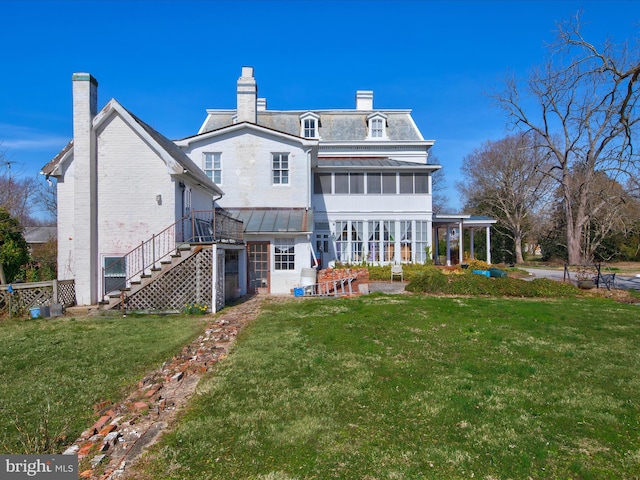 rear view of property with a lawn