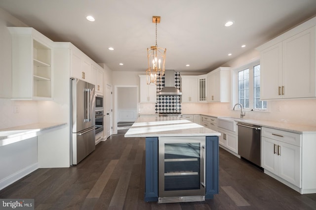 kitchen featuring beverage cooler, dark wood-type flooring, appliances with stainless steel finishes, wall chimney exhaust hood, and white cabinets