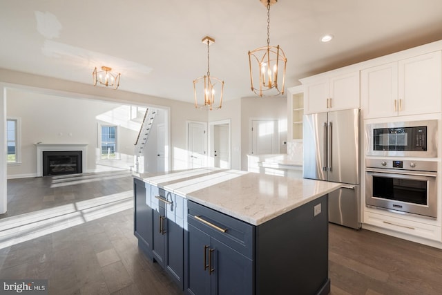 kitchen with dark hardwood / wood-style flooring, decorative light fixtures, appliances with stainless steel finishes, white cabinetry, and a center island