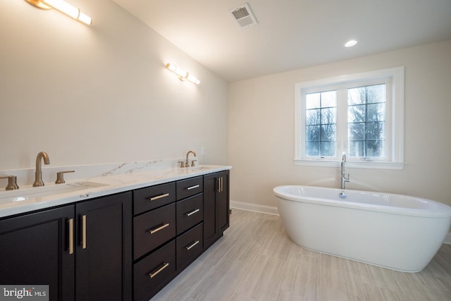 bathroom with tile floors, dual vanity, and a bathtub