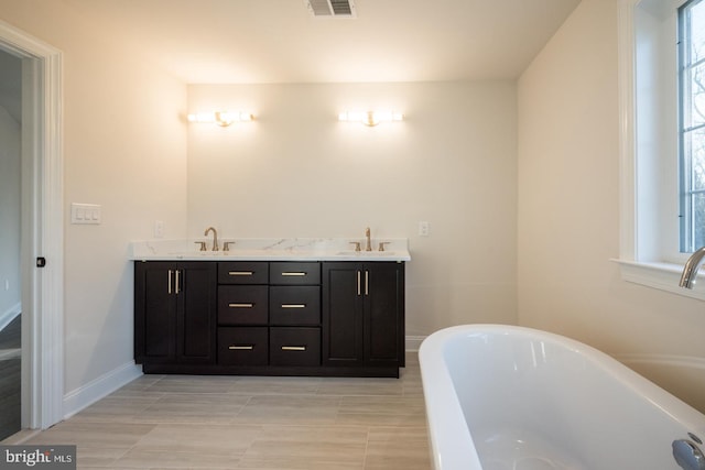 bathroom featuring tile floors, a washtub, and dual vanity