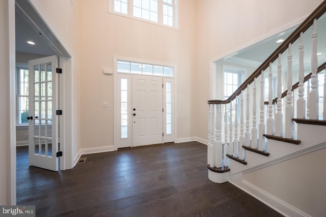 foyer entrance with dark hardwood / wood-style flooring, french doors, and a high ceiling