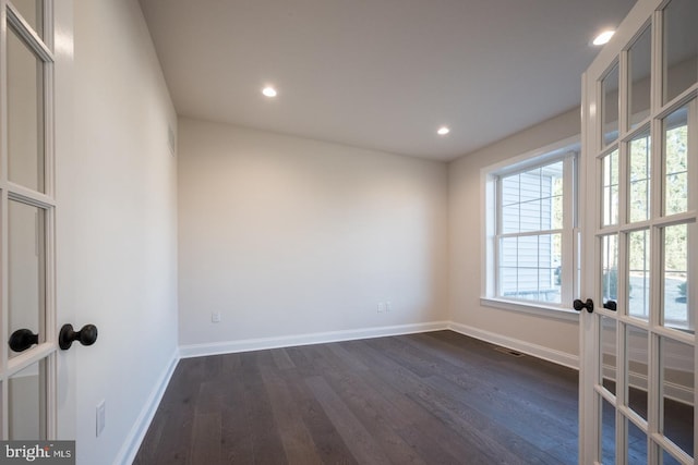 empty room featuring french doors and dark hardwood / wood-style flooring